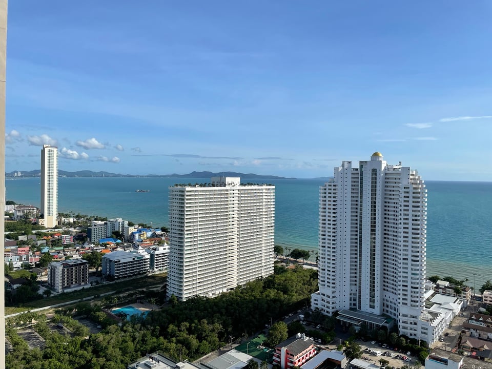An elevated view along Jomtien Beach, with the sea and coastal buildings, in 2021.